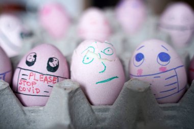 Paskalya tatili dekorasyonu için maske takarak kendin yap. Kopyalama alanı ile seçmeli odak. COVID-19 koruması. Corona virüslü Paskalya yumurtaları COVID19 koruma kavramları.