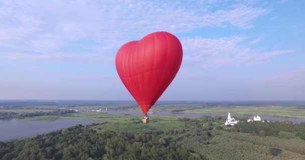 Roter Heißluftballon in Herzform in der Luft. Rundumblick, Antenne. — Stockvideo