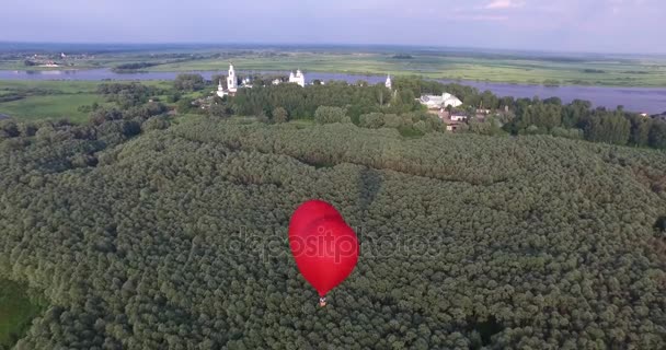 Globo de aire caliente rojo en forma de corazón en el aire. Vista alrededor, aérea . — Vídeo de stock