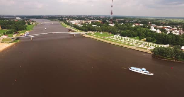 Cruzando el puente peatonal de madera sobre el pequeño río . — Vídeos de Stock