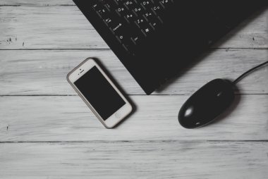 bir bilgisayar fare ve masada bir telefon