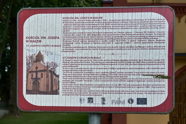 Biale, Polonia - 04 de agosto de 2017: Placa informativa frente a la Iglesia p.w. San José en Biale, Gostynin. Polonia. Fue elevado en 1636, con el consentimiento del obispo Stanislaw Lubienski . — Foto de Stock