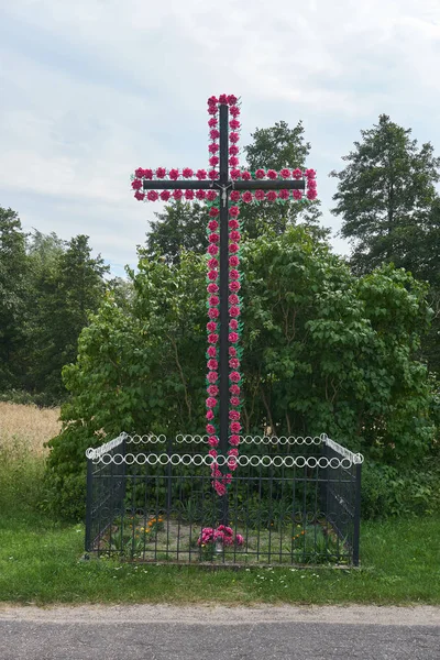 Cachapel cattolico tradizionale vicino alla strada a forma di croce con fiori artificiali di plastica, Biale, Polonia — Foto Stock