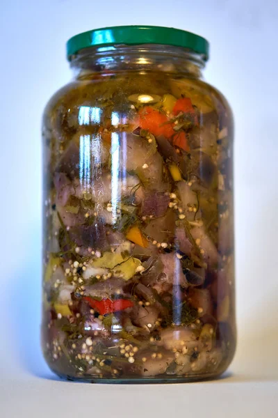 Spicy dish of classical folk Bulgarian and Russian cuisine: marinated eggplants with hot pepper in vinegar and vegetable oil in a glass jar - homemade pickles, blanks for the winter — Stock Photo, Image