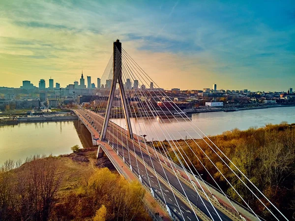 Beautiful panoramic aerial dsrone view to Swietokrzyski Bridge (English: Holy Cross Bridge) - is a cable-stayed bridge over the Vistula river in Warsaw, Poland in autumn November evening at sunset — Stock Photo, Image