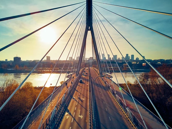 Bela vista panorâmica do pôr-do-sol do drone aéreo para o centro da cidade de Varsóvia com arranha-céus e a ponte Swietokrzyski (En: Holy Cross Bridge) é uma ponte suspensa por cabo sobre o rio Vístula em Varsóvia, Polônia — Fotografia de Stock