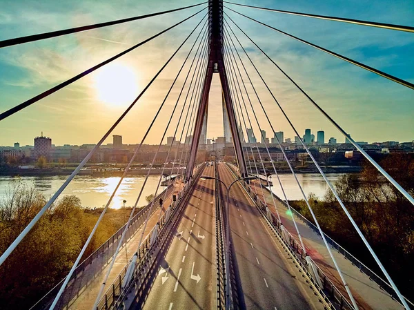 Bela vista panorâmica do pôr-do-sol do drone aéreo para o centro da cidade de Varsóvia com arranha-céus e a ponte Swietokrzyski (En: Holy Cross Bridge) é uma ponte suspensa por cabo sobre o rio Vístula em Varsóvia, Polônia — Fotografia de Stock