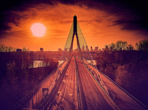 Beautiful panoramic aerial dsrone view to Swietokrzyski Bridge (English: Holy Cross Bridge) - is a cable-stayed bridge over the Vistula river in Warsaw, Poland in autumn November evening at sunset — Stock Photo, Image