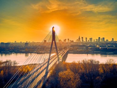 Beautiful panoramic aerial drone sunset view to Warsaw city center with skyscrapers and Swietokrzyski Bridge (En: Holy Cross Bridge) - is a cable-stayed bridge over the Vistula river in Warsaw, Poland clipart