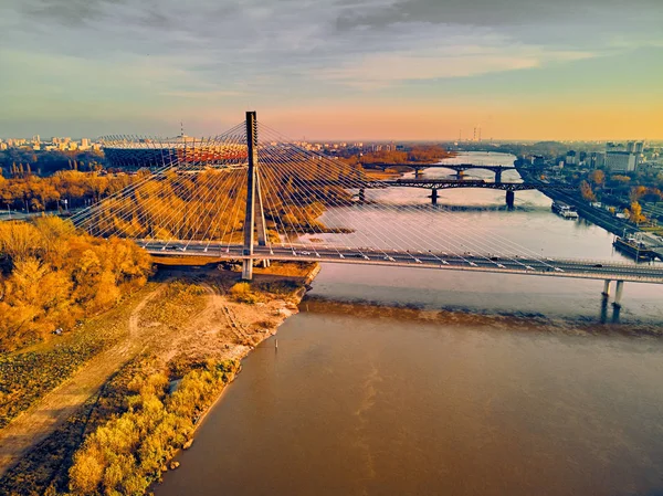 Prachtig panoramisch uitzicht vanuit de lucht op de Swietokrzyski-brug (Pools: Swietokrzyski) en het Pge Narodowy of het nationale stadion - voetbalstadion in Warschau, Polen in de herfst 's avonds bij zonsondergang — Stockfoto