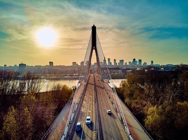 Bela vista panorâmica de drones aéreos para a Ponte Swietokrzyski (em inglês: Holy Cross Bridge) é uma ponte sobre o rio Vístula, em Varsóvia, Polônia, no outono à noite de novembro, ao pôr do sol. — Fotografia de Stock