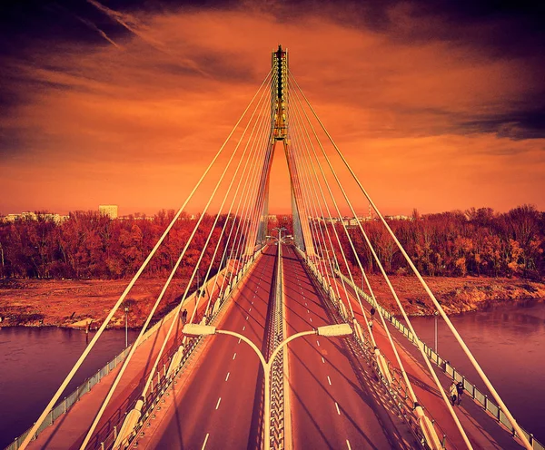 Beautiful panoramic aerial dsrone view to Swietokrzyski Bridge (English: Holy Cross Bridge) - is a cable-stayed bridge over the Vistula river in Warsaw, Poland in autumn November evening at sunset — Stock Photo, Image