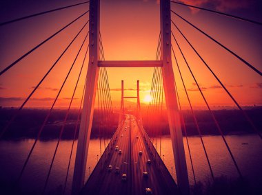 Vistula nehri ve Varşova şehri gökdelenleri üzerindeki Siekierkowski Köprüsü 'ne güzel panoramik hava aracı görüntüsü Kasım akşamı günbatımında Polonya' nın altın kırmızısı sonbahar renklerinde.