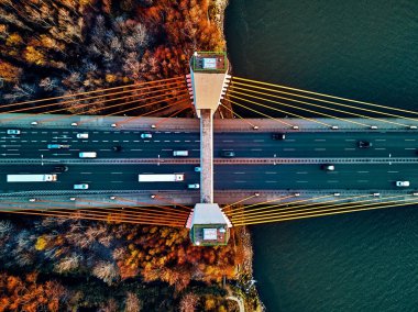 Vistula nehri ve Varşova şehri gökdelenleri üzerindeki Siekierkowski Köprüsü 'ne güzel panoramik hava aracı görüntüsü Kasım akşamında Polonya' da altın kırmızısı sonbahar renkleriyle günbatımında tepeden aşağı