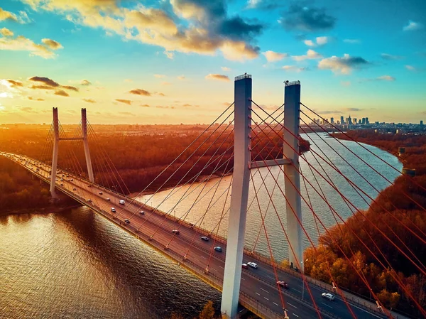 Bela vista panorâmica de drones aéreos para a ponte Siekierkowski sobre o rio Vístula e arranha-céus da cidade de Varsóvia, na Polônia, em cores vermelhas douradas do outono, em novembro à noite, ao pôr do sol — Fotografia de Stock