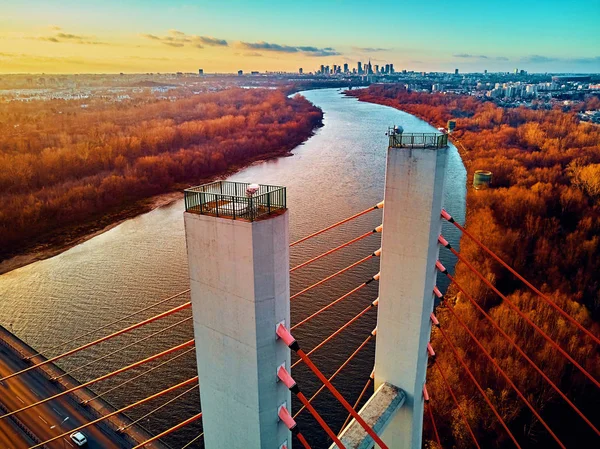 Bela vista panorâmica de drones aéreos para a ponte Siekierkowski sobre o rio Vístula e arranha-céus da cidade de Varsóvia, na Polônia, em cores vermelhas douradas do outono, em novembro à noite, ao pôr do sol — Fotografia de Stock