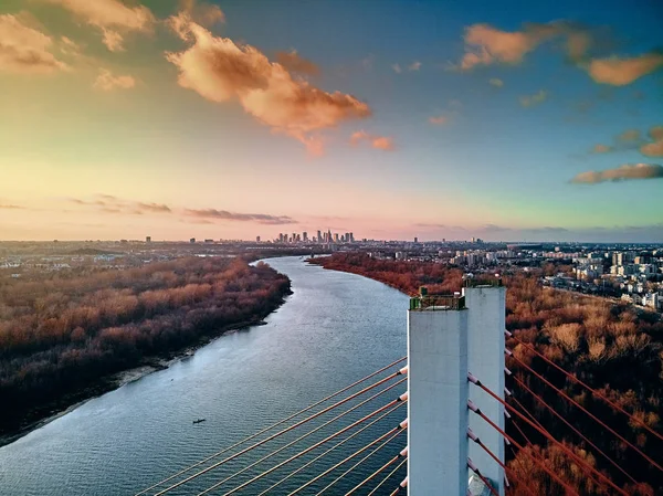 Hermosa vista panorámica del dron aéreo al puente de Siekierkowski por cable sobre el río Vístula y los rascacielos de la ciudad de Varsovia, Polonia en colores dorados de otoño rojo en la noche de noviembre al atardecer — Foto de Stock