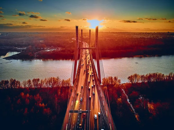 Bela vista panorâmica de drones aéreos para a ponte Siekierkowski sobre o rio Vístula e arranha-céus da cidade de Varsóvia, na Polônia, em cores vermelhas douradas do outono, em novembro à noite, ao pôr do sol — Fotografia de Stock