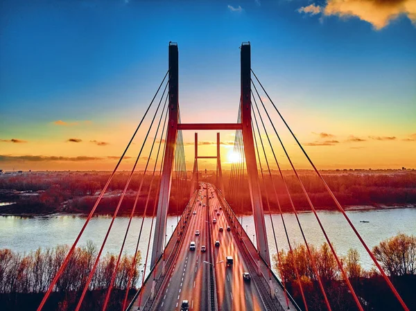 Bela vista panorâmica de drones aéreos para a ponte Siekierkowski sobre o rio Vístula e arranha-céus da cidade de Varsóvia, na Polônia, em cores vermelhas douradas do outono, em novembro à noite, ao pôr do sol — Fotografia de Stock