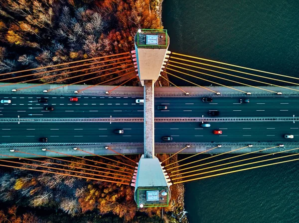 Vistula nehri ve Varşova şehri gökdelenleri üzerindeki Siekierkowski Köprüsü 'ne güzel panoramik hava aracı görüntüsü Kasım akşamında Polonya' da altın kırmızısı sonbahar renkleriyle günbatımında tepeden aşağı