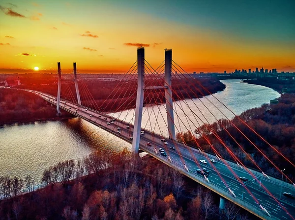 Hermosa vista panorámica del dron aéreo al puente de Siekierkowski por cable sobre el río Vístula y los rascacielos de la ciudad de Varsovia, Polonia en colores dorados de otoño rojo en la noche de noviembre al atardecer — Foto de Stock