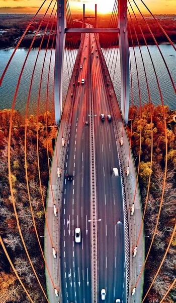 Hermosa vista panorámica del dron aéreo al puente de Siekierkowski por cable sobre el río Vístula y los rascacielos de la ciudad de Varsovia, Polonia en colores dorados de otoño rojo en la noche de noviembre al atardecer — Foto de Stock