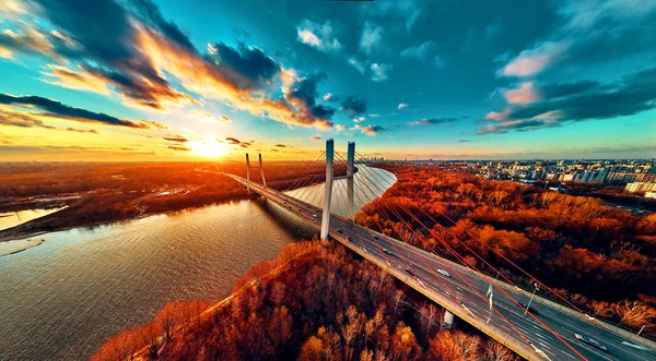 Hermosa vista panorámica del dron aéreo al puente de Siekierkowski por cable sobre el río Vístula y los rascacielos de la ciudad de Varsovia, Polonia en colores dorados de otoño rojo en la noche de noviembre al atardecer — Foto de Stock