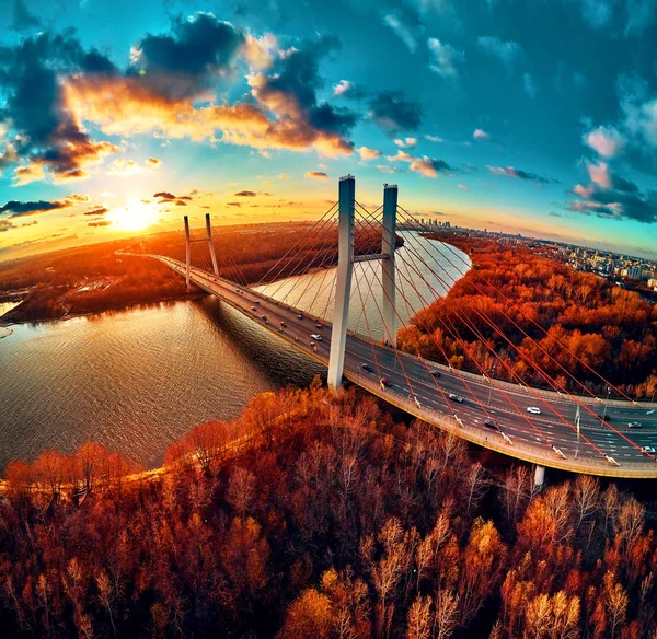 Hermosa vista panorámica del dron aéreo al puente de Siekierkowski por cable sobre el río Vístula y los rascacielos de la ciudad de Varsovia, Polonia en colores dorados de otoño rojo en la noche de noviembre al atardecer — Foto de Stock