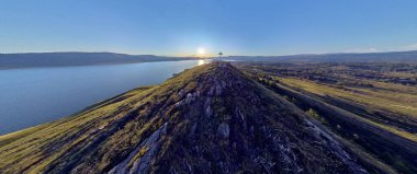 Dağın tepesinde bir Ortodoks haçı olan Doğu Kazakistan 'da, Irtysh nehrinin kıyısındaki Bukhtarma rezervuarındaki yaz tatili tesislerine güzel bir panoramik hava aracı manzarası.