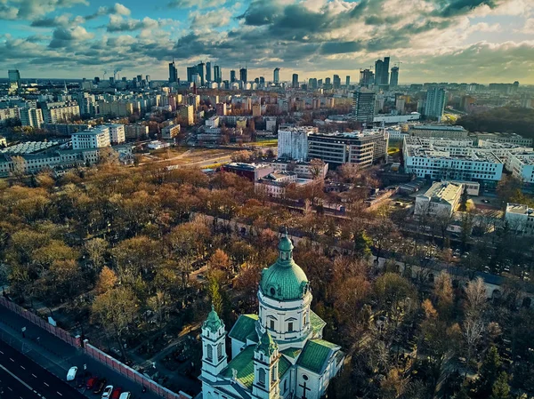 Beautiful panoramic aerial drone view to the ?enter of modern Warsaw city with silhouettes of skyscrapers and Church Karol Boromeusz (at the Powazki Cemetery) in amazing winter January sunset, Poland — Stock Photo, Image