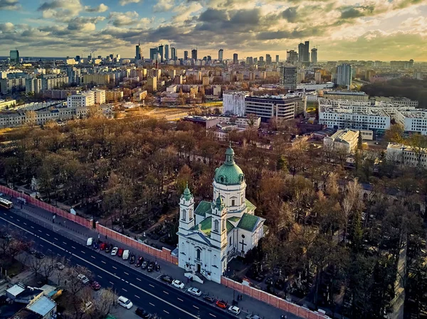 Wunderschöne panoramische Drohnenaufnahme zum Eingang der modernen Warschauer Stadt mit Silhouetten von Wolkenkratzern und der Kirche Karol Boromeusz (auf dem Powazki-Friedhof) im wunderschönen Winter im Januar Sonnenuntergang, Polen — Stockfoto