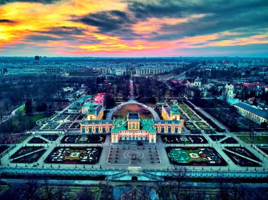 Beautiful panoramic aerial drone view to Wilanow Palace or Wilanowski Palace - is a royal palace located in the Wilanow district, Warsaw, Poland in gold red colors at warm January sunset clipart