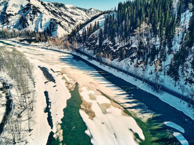 Panoramik hava manzarası: güzel bahar manzarası: Kazakistan 'daki Ulba nehri kış uykusundan uyanıyor - buz kayması - dağlarda eriyip gidiyor, parlak güneş parlıyor, Kazakistan