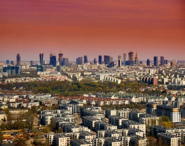 Güzel panoramik şehir manzarası - Varşova 'nın merkezine inen uçağın penceresinden manzara (Polonya) gökdelenlerle, parklarla ve yerleşim alanlarıyla, bahar başında gün batımında