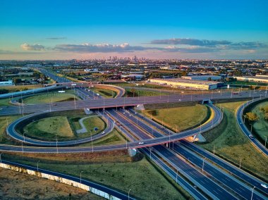 A beautiful panoramic aerial drone view of the sunset on the highway overpass of the southern Warsaw bypass (Polish: POW), Michalowice district in Warsaw, Opacz Kolonia, Poland clipart