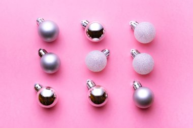 Xmas deseni. Pembe arka planda izole edilmiş dekorasyonlar için Noel baloları. Düz yatıyordu. Soyut kış konsepti.