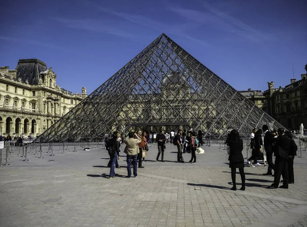 Pessoas caminhando perto da Pirâmide do Louvre — Fotografia de Stock