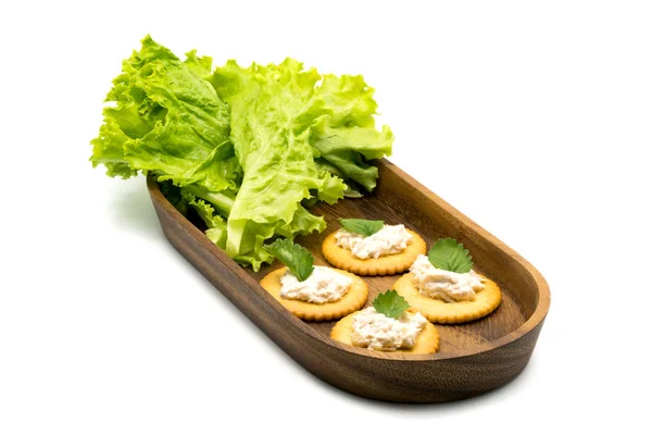Biscuiți rotunde cu ton răspândit și legume în tavă de lemn — Fotografie, imagine de stoc