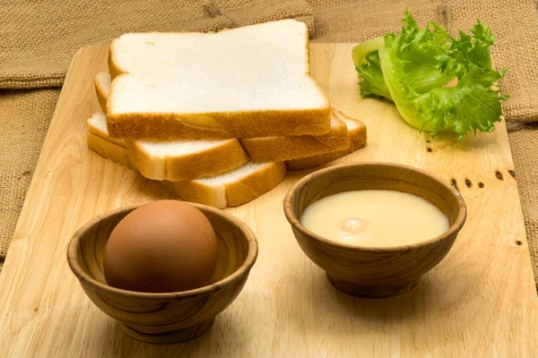 Stapel gesneden brood, gezoete gecondenseerde melk en ei — Stockfoto