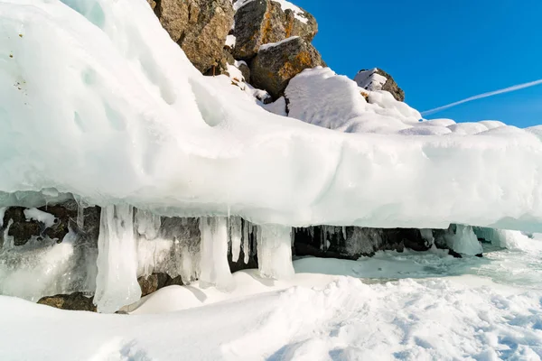 Ijsgrot met ijspegels aan de berg in het Baikalmeer — Stockfoto