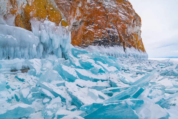 Blått, frossent vann dekket med snø og istapper – stockfoto