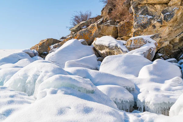 Eau gelée et rochers recouverts de neige — Photo