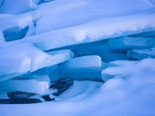 Ijsblokken bedekt met sneeuw op bevroren Baikalmeer — Stockfoto