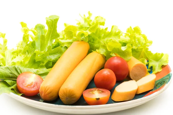 Kolbász, a paradicsom és a saláta a többszínű kerámia tányér — Stock Fotó