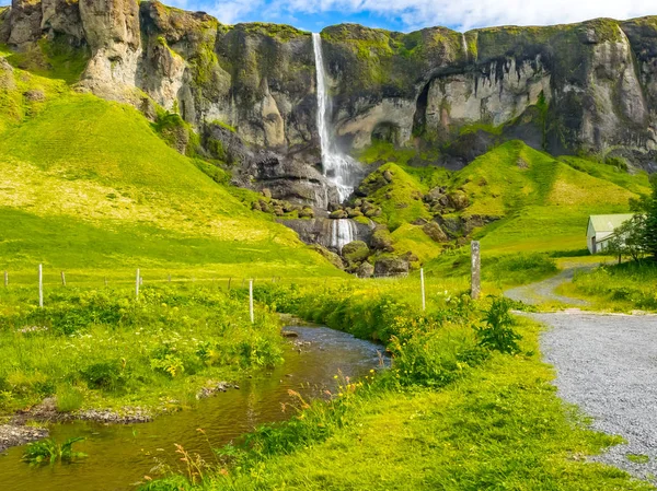 Vista da cachoeira alta e do campo de flores amarelas — Fotografia de Stock