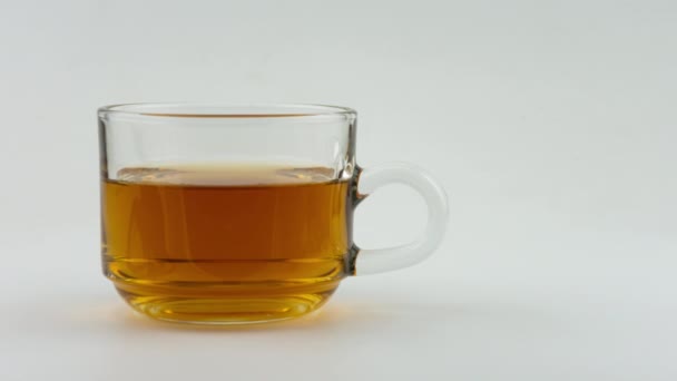Boire du thé chaud dans un verre sur fond blanc dans Stop Motion .