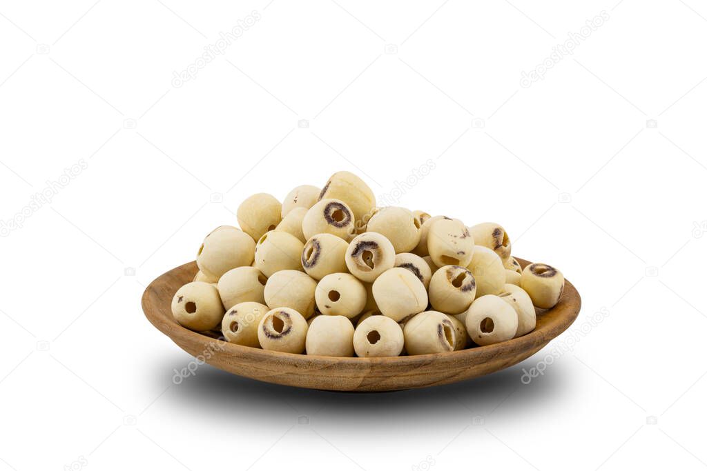 Pile of Dried Lotus Seeds in a wooden plate on white background with clipping path. Nowadays lotus seed become popular healthy food and has highly beneficial for health.