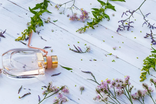 Botella Perfume Rodeada Flores Frescas Sobre Fondo Madera — Foto de Stock