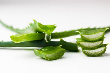 aloe vera beyaz arkaplanda akan meyve suyu ile yakın plandan ayrılıyor