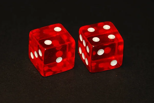 two dice on a black desk, result six (6), two (2) and four (4)